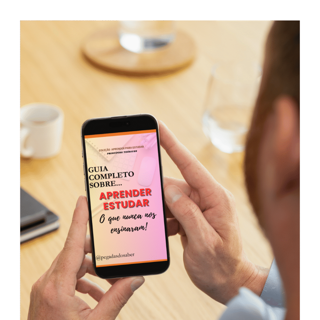 Pessoa segurando um celular que exibe a capa do e-book “Aprender Estudar: O que nunca nos ensinaram”, em fundo rosa com o título em destaque e o perfil @pegadasdosaber, em um ambiente de mesa com xícara e caderno ao fundo.
